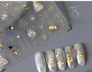 Macro detail of gold embossed Christmas nail stickers with snowflake and tree patterns