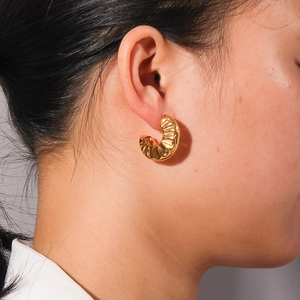 Elegance 18K gold plated stainless steel C-shape pumpkin texture earrings on a model