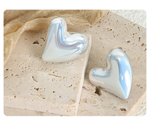 Close-up of heart-shaped titanium steel earrings with high-polish silver finish