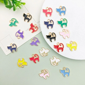 Detailed close-up of colorful enamel cat pendants with gold metal edges and hanging loops