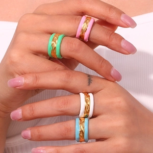 Macro detail of wide wavy rings with vibrant colorful enamel on polished gold plating