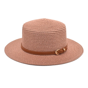 Detailed close-up of pink straw boater hat with a brown leather belt and golden buckle