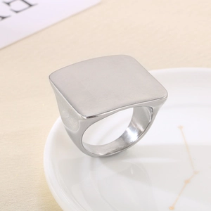 Macro shot of silver titanium square signet ring with a brushed matte finish on a ceramic plate