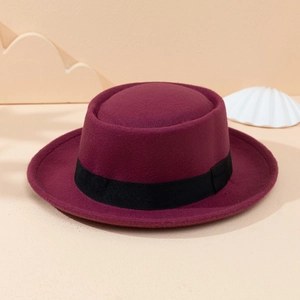 Close-up of burgundy wool pork pie hat featuring a stylish wide black grosgrain ribbon