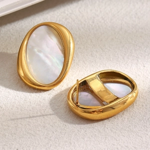 Close-up of gold plated stainless steel oval earrings with white mother of pearl inlay