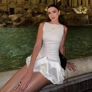 Détail d'une mini robe en satin blanc sans manches avec ourlet à volants