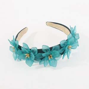 Détail des fleurs en résine 3D bleu sarcelle et étamines dorées sur un bandeau bleu