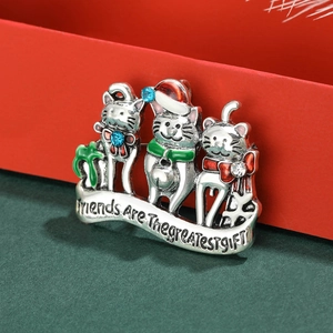 Macro shot of three cute Christmas cats brooch with enamel finish and holiday quote
