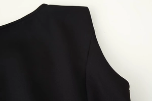 Detail of round neckline and shoulder padding on a black woven dress for women