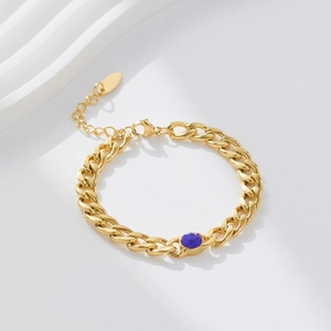 Detail of 18k gold plated stainless steel Cuban bracelet with a blue zircon gemstone