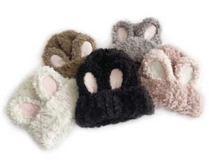 Flat lay of sweet rabbit ear knit beanies in white, brown, grey, black, and pink colors