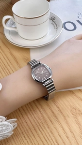 Close-up of NAIDU square brown dial watch with silver strap worn in a lifestyle setting