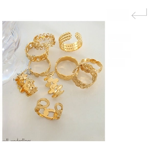 Flat lay of multiple gold-plated geometric rings with floral and braided textures
