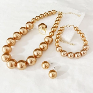 Detailed view of elegant gold pearl jewelry set with necklace, bracelet and earrings