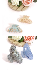 French retro acrylic hair claws in marble patterns and mermaid colors on a wooden tray