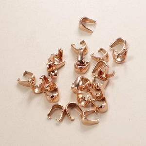 Macro shot of rose gold stainless steel pendant pinch bails for DIY jewelry making