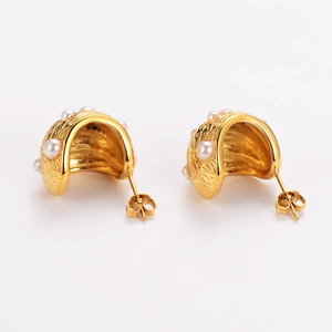 French vintage gold earrings with textured metal finish and white pearls on white background