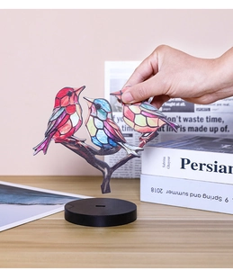 Detail of colorful acrylic birds desktop ornament with black base for office decor