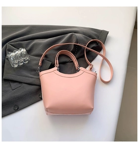 Detailed top view of pink embroidered bucket bag with leather handles and strap