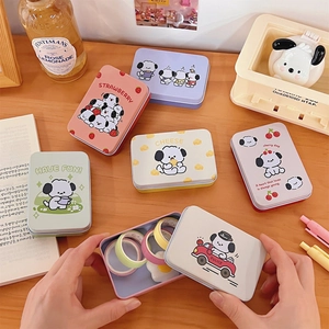 Close-up of cute cartoon tin storage boxes with various themes on a cozy wooden desk
