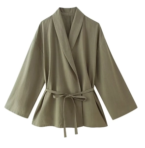 Detail of green linen wrap top featuring a V-neckline and adjustable waist tie belt