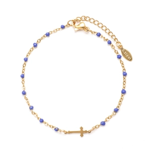 Detail of gold stainless steel bracelet with blue beads and a cross pendant detail