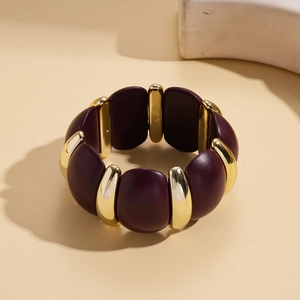 Detail of wide chunky bracelet featuring purple leather modules and gold metal spacers