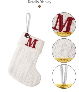 Detail display of white cable knit Christmas stocking with red embroidered letter M