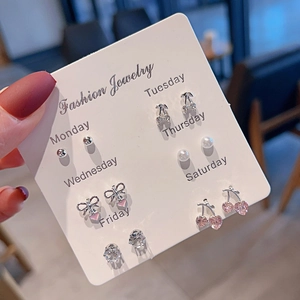 Detail view of 7 pairs set featuring cherry, heart, bow, and pearl stud earrings