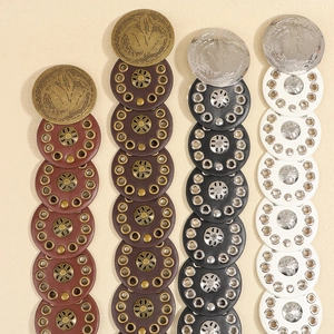 Detail of four retro punk waist belts in brown, black and white with metal studs