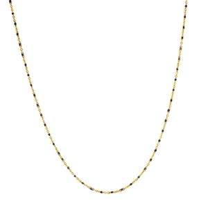 Detailed close-up of golden chain necklace with small black beads on white background