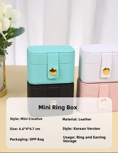Vertical stack of mini faux leather jewelry boxes in blue white black and pink colors