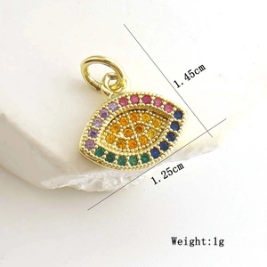 Macro detail of gold evil eye pendant with colorful cubic zirconia and dimensions