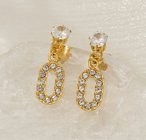 Macro shot of gold-plated crossover stud earrings featuring brilliant-cut cubic zirconia