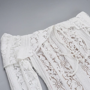 Detail of white floral lace texture and drawstring design on an off-shoulder dress