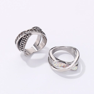 Macro view of crossover rings with sparkling pave crystals and iridescent inlays
