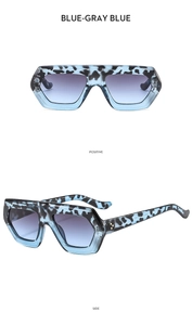 Detail of blue-gray thick hexagonal frame sunglasses with gradient lenses and gold dots