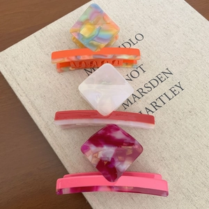 Colorful marble acetate hair clips and claw set for women on a beige book background