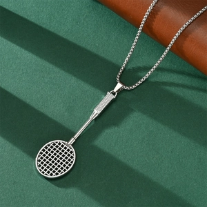Detailed view of silver badminton racket pendant necklace on textured green background