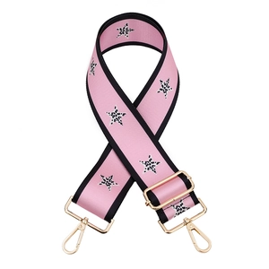Macro detail of adjustable pink bag strap featuring leopard print stars and gold hardware