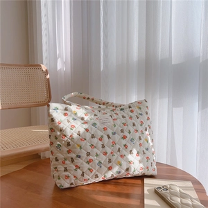 Detail of the quilted texture with vintage bear and floral patterns on the tote bag