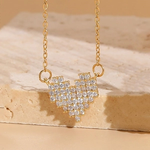 Golden pixel heart necklace with zircon inlay on a minimalist stone background display