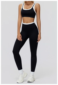 Close-up of high-waist yoga leggings and sports bra with contrast piping and elastic fabric