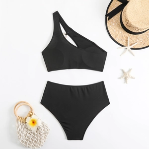 Flat lay of black one-shoulder bikini with gold chain link and ribbed texture details