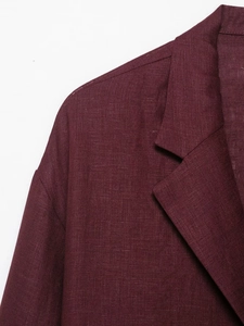 Detail of burgundy linen suit blazer showing fabric texture and lapel craftsmanship