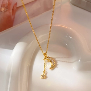 Golden moon and star necklace with square zircon stones on elegant ceramic stand