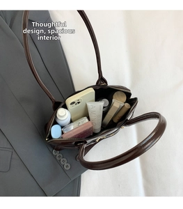 Spacious interior of a brown oil wax leather shell bag showing daily essentials
