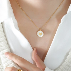 Minimalist gold titanium necklace with a two-tone round heart pendant worn by a model