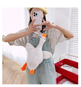 Detailed view of soft plush white goose bag worn by a model in casual home setting