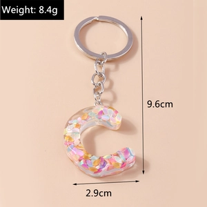 Detailed view of resin letter C keychain with colorful sequins and silver metal ring